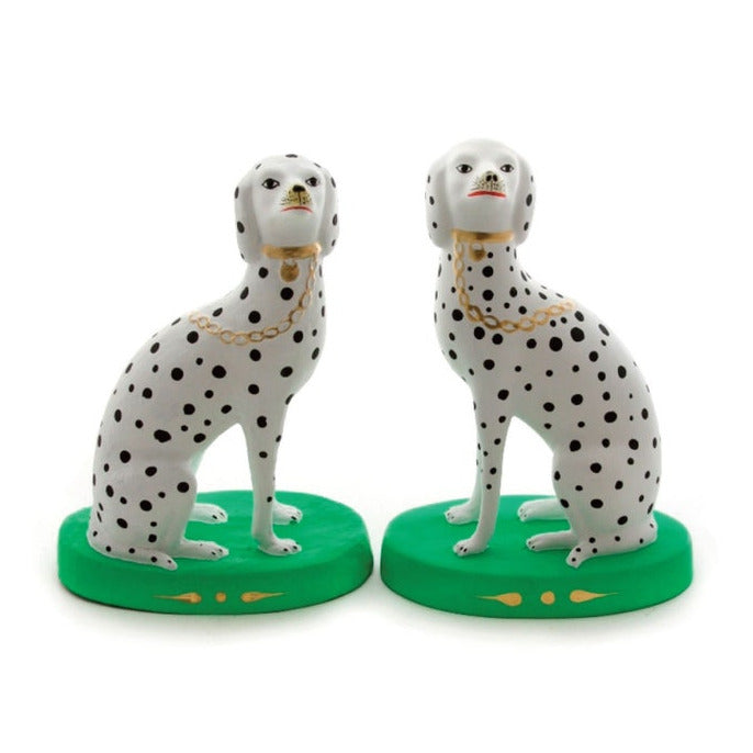 Two Dalmatian dog figurines on green bases with a white background