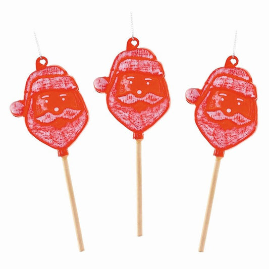 Three red candy lollipops with Santa Claus faces and wooden sticks on a white background