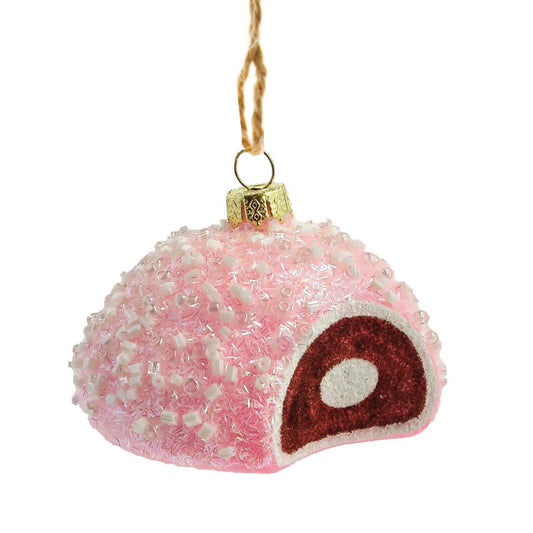 Pink textured snowball-shaped ornament with a small bite out of the side showing chocolate colored cake and white cream filling on a white background