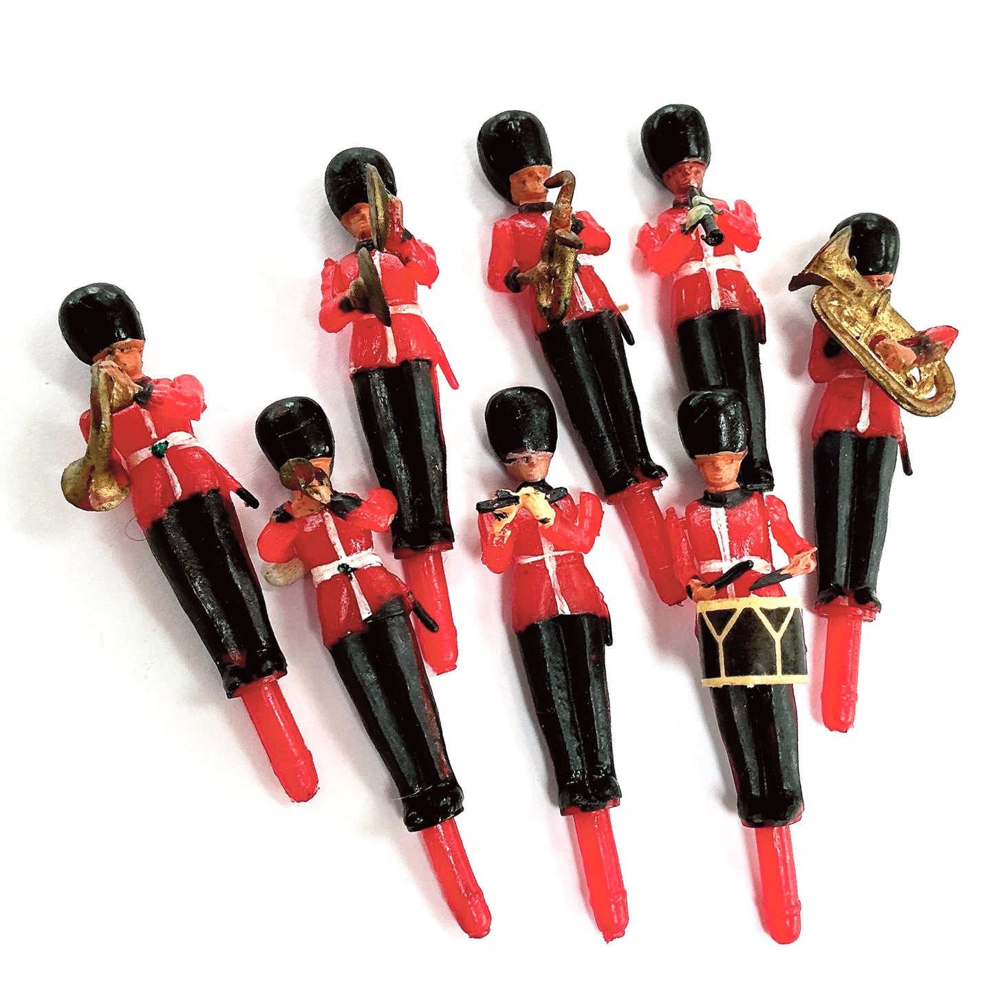 Set of toy soldiers in red uniforms with musical instruments on a white background