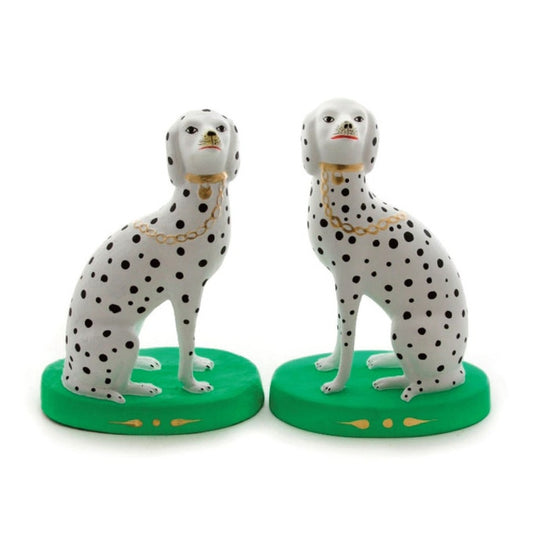 Two Dalmatian dog figurines on green bases with a white background