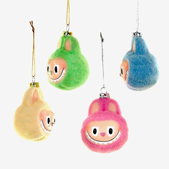 Set of colorful plush ornaments shaped like cartoon character monsters on a white background