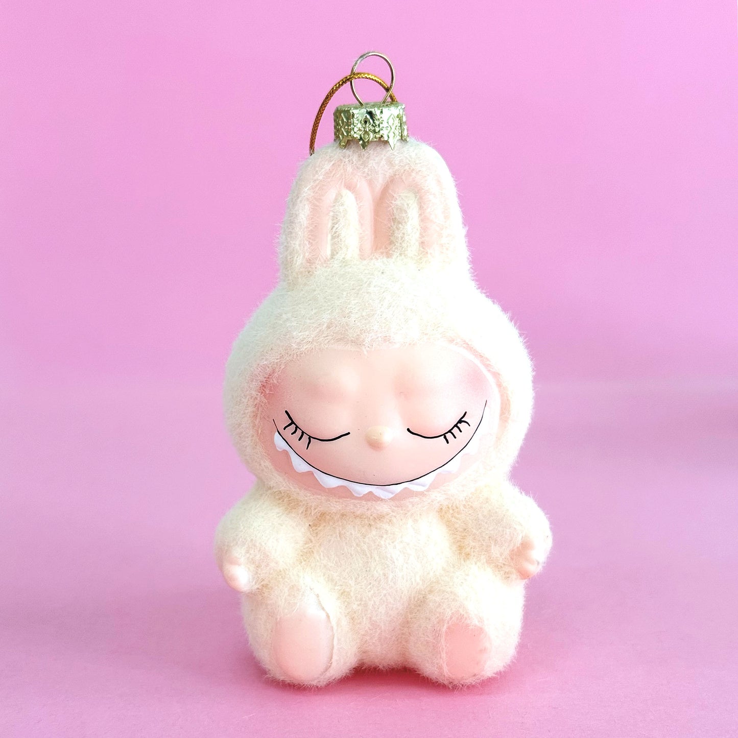 Plush toy with bunny ears on a pink background