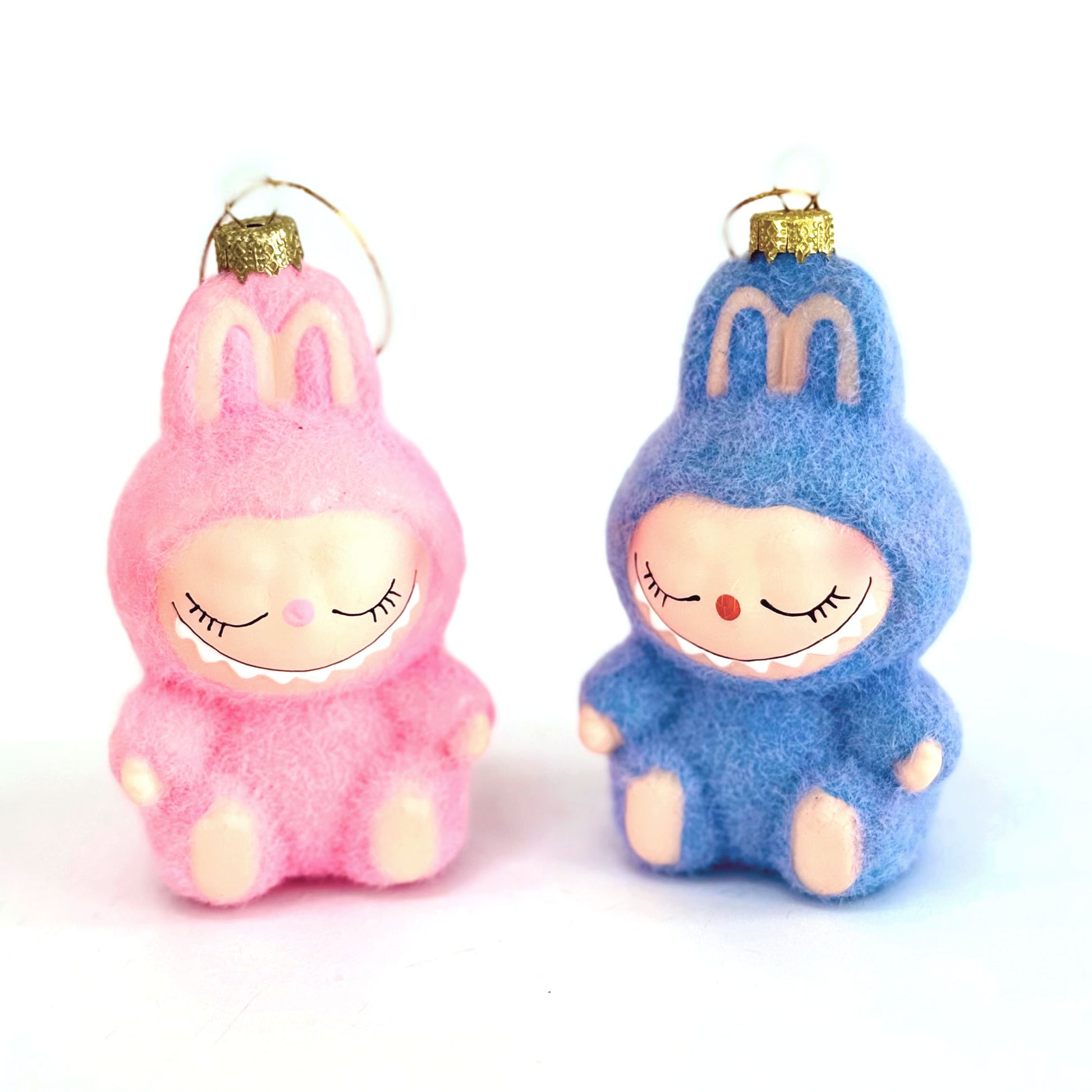 Pink and blue plush toys with a smiley face design on a white background